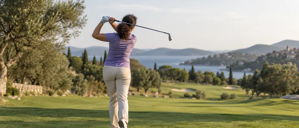 Golfer u zamahu na zelenom terenu